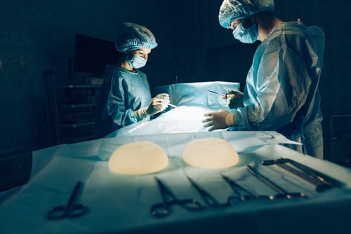 Surgical Team with Breast Implants in Foreground