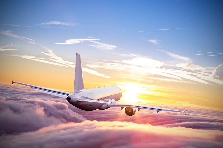 Commercial,Airplane,Flying,Above,Clouds,In,Dramatic,Sunset,Light.,Very